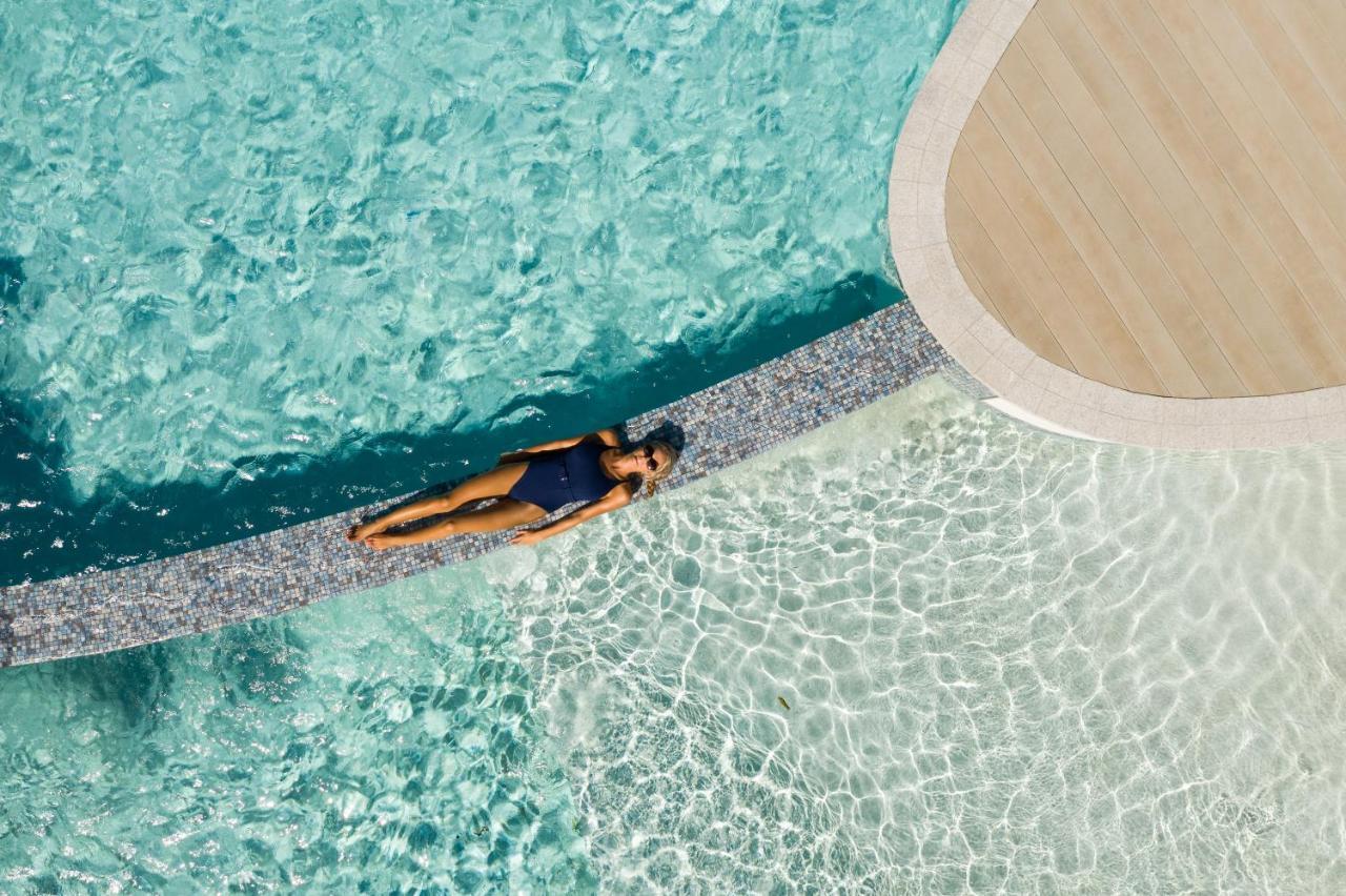 คริสตัลบรูค ไรลีย์ Hotel แคนส์ ภายนอก รูปภาพ Aerial view of a woman sunbathing in a swimming pool